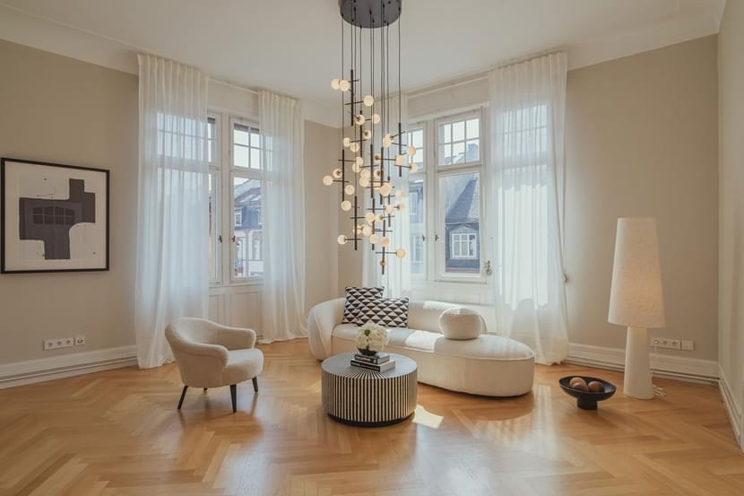 Bild nach dem möblieren der Musterwohnung. Ein eleganter, moderner Wohnraum mit luxuriösem Bodenbelag und einer elektrischen Lampe, gesehen durch ein Fenster in einem Wohnraum. Dieses Innenapartment strahlt Eleganz und Stil aus.