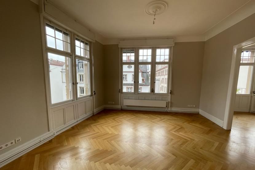 Bild vor dem möblieren der Musterwohnung. Ein modernes Wohninterieur mit Holzböden, Wänden und anderen Gebäudeelementen, gestaltet mit einem Materialmix, um einen einladenden Wohnraum zu schaffen.