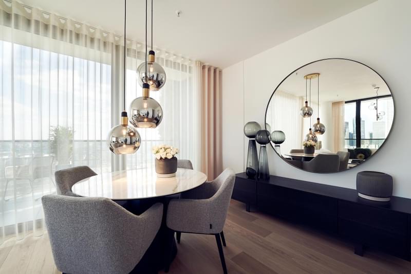 Eine Innenansicht eines modernen, luxuriösen Wohnraums mit eleganter Architektur, einem Designtisch, Bodenbelag und Fenster.
