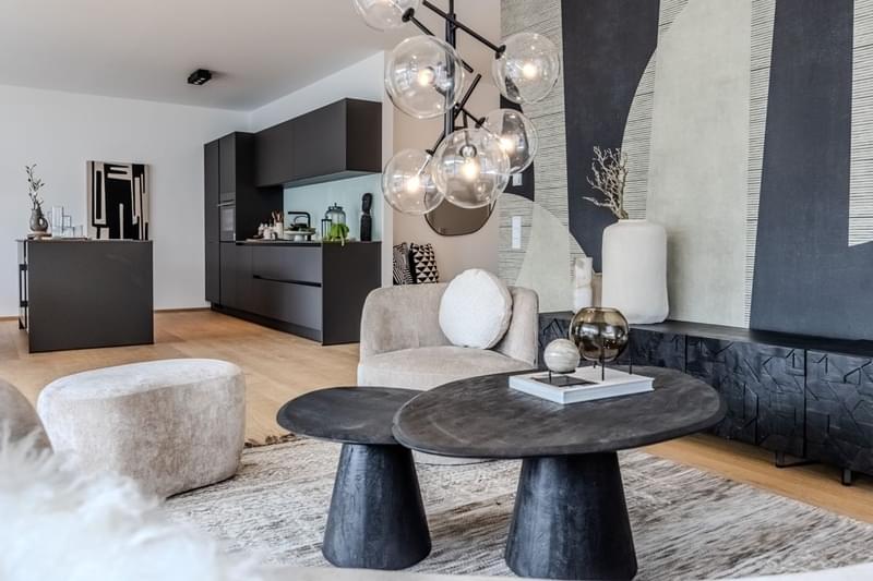 Ein modernes Innendesign eines Wohnraums im Innenbereich mit einem Tisch im Vordergrund und einer auffallenden Lampe.