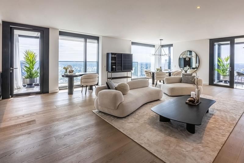 Ein geräumiges modernes Innendesign mit einer Couch und Tisch und großen Fensterfronten.