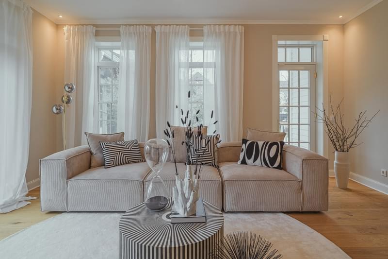 Ein klassisch modernes und elegantes Innendesign im Wohnzimmer einer Villa mit einer großen Couch.