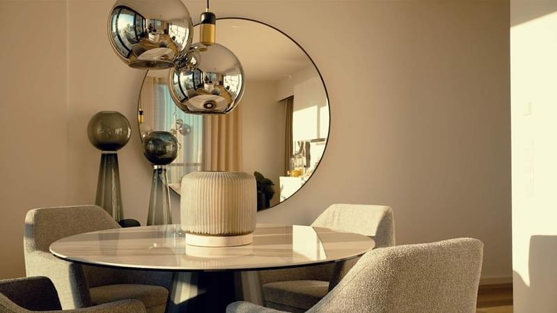 Video-Teaser der Musterwohnung EDEN in Frankfurt, die ein modernes Wohnzimmer mit elegantem Tisch- und Stuhldesign, luxuriösem Holzboden und atemberaubender Architektur zeigt.
